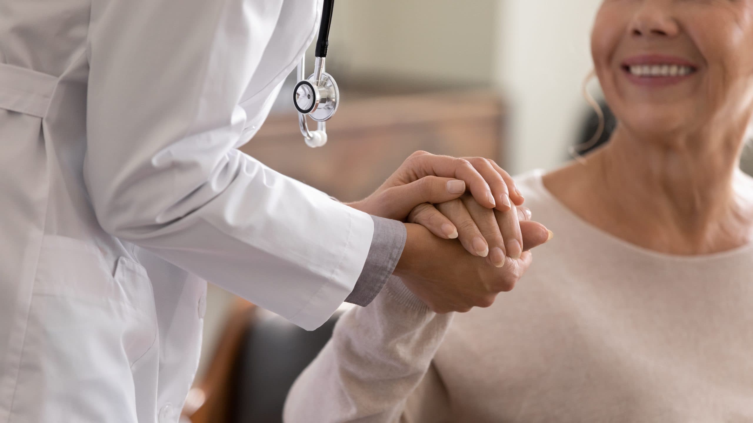 Doctor holding patient's hand in support